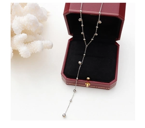 Detail of silver long tassel bead necklace displayed in an elegant red jewelry box