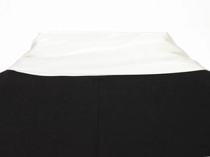 Vue détaillée d'un blazer noir avec revers en satin blanc contrastant de qualité