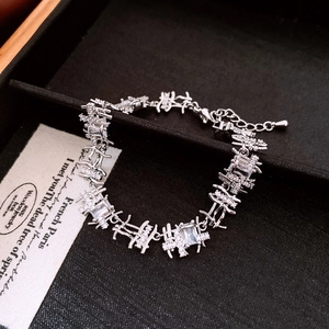 Macro shot of silver-tone irregular branch chain with baguette zircons and lobster clasp