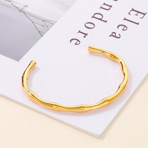 Close-up of golden bamboo texture and polished finish on stainless steel open bangle