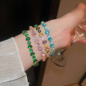 Détail de quatre bracelets en zircon coloré portés au poignet dans un cadre très élégant