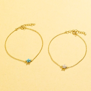 Detailed view of two flower bracelets in gold finish with turquoise and clear stones