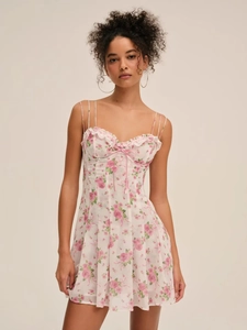 Detail of floral mini dress featuring lace trim and a delicate pink ribbon bow on the chest