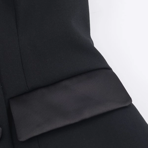 Detail of a black halter top with satin contrast pocket and premium matte fabric texture