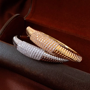 Macro di bracciali rigidi in oro e argento con pavé di zirconi e design a coste fitte