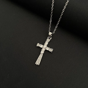 Collier croix en argent poli avec zircons blancs étincelants sur tissu noir