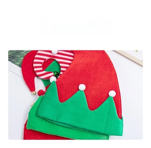 Dettaglio cappello da elfo di Natale rosso e verde con pompon bianchi e campanellini in metallo