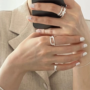 Close-up of minimalist 925 sterling silver chain rings layered on hand for an elegant look
