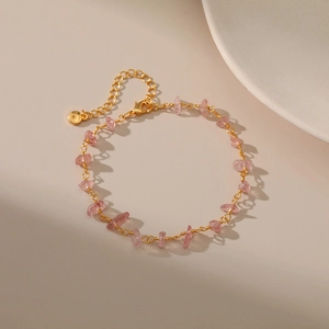 Detail of 18K gold chain bracelet featuring light pink crystal stones and lobster clasp