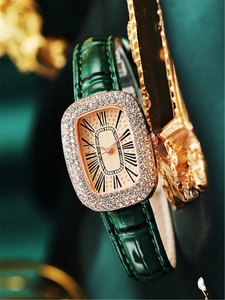 Close-up of luxury green leather watch with crystal-encrusted gold-tone square dial