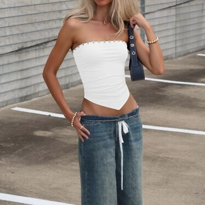Détail du haut bustier blanc avec œillets métalliques et coupe d'ourlet asymétrique
