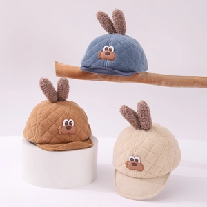 Detail of baby quilted baseball caps with plush bunny ears and cute dog patch accents