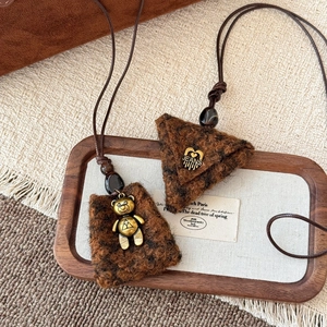 Detail of plush brown teddy bear charms with vintage gold hardware on long cord necklaces