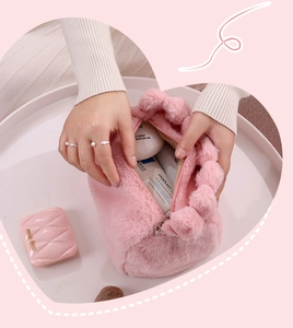 Close-up of soft pink plush faux rabbit fur makeup bag showing interior contents