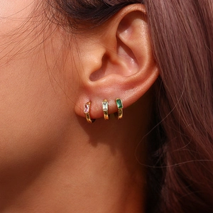 Lot de trois boucles d'oreilles dorées avec zircon rectangulaire portées par mannequin
