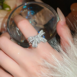 Close-up of a silver bow ring with shimmering cubic zirconia on a female finger