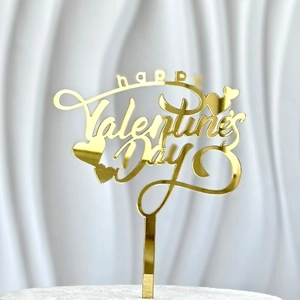 Macro detail of golden acrylic Happy Valentine's Day cake topper with heart motifs
