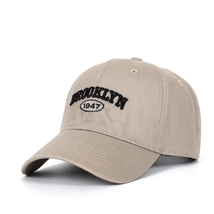 Detail of khaki baseball cap with black Brooklyn 1947 embroidery and curved brim