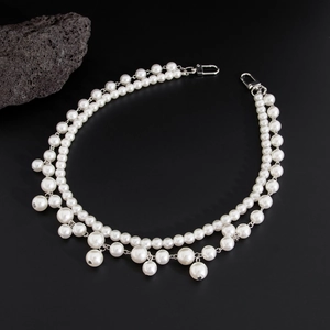 Close-up of double-layer faux pearl waist chain with silver hardware on black background