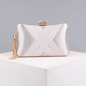 Detail of silver satin evening clutch with woven design and long gold tassel charms