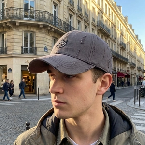 Distressed charcoal gray baseball cap with metal B letter embroidery in urban street setting