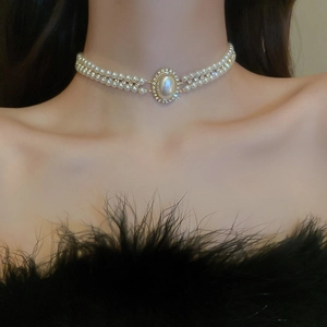 Détail du collier ras du cou en perles baroques avec strass et chaîne dorée double