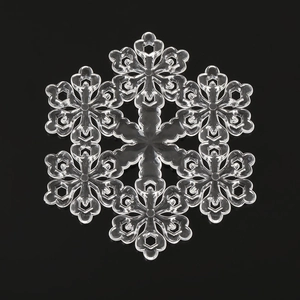 Macro detail of clear acrylic Christmas snowflake ornament with intricate geometric patterns