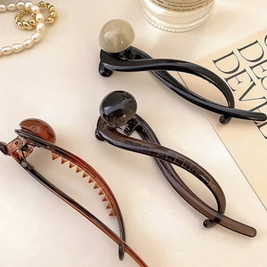 Elegant twist hair clips with pearl and marble accents in a stylish fashion setting