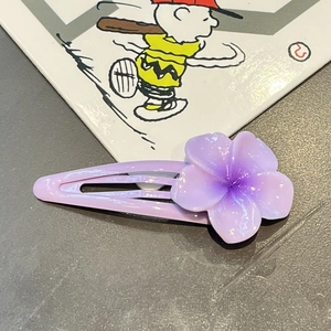 Macro shot of sweet purple resin flower hair clip with gradient petals and metal bb grip