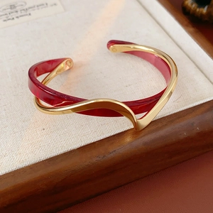 Detail of French style gold-plated double-layer geometric bangle with red resin inlay