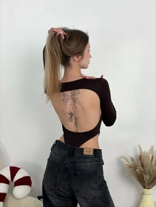 Close-up of ribbed bodysuit showing backless cutout design with black denim jeans