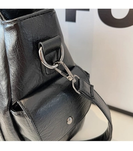 Close-up of black lychee grain leather tote bag with metallic D-ring and lobster clasp