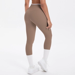Détail du legging de yoga marron à taille haute avec bordure blanche et baskets