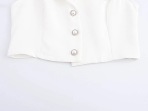 Detail of white vest featuring three silver buttons with elegant pearl centers