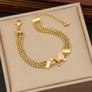Elegant gold butterfly tassel necklace with layered stainless steel chains on jewelry box