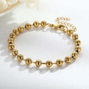 Detailed shot of golden stainless steel ball chain bracelet with lobster clasp and extender