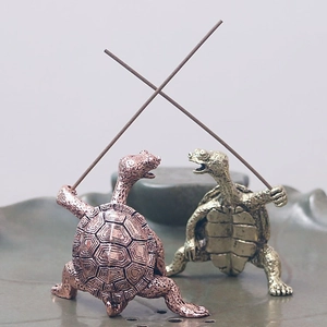 Detail of creative antique turtle incense holder standing with raised paws in brass finish