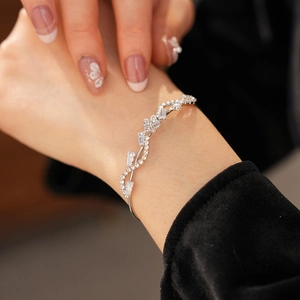 Handgelenk-Detail eines silbernen Blumenarmbands mit Zirkonsteinen am Modell