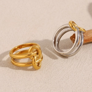 Detail of intertwined two-tone 18K gold plated stainless steel knotted double layer rings