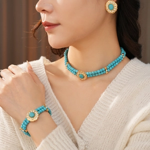 Détail d'un ensemble de collier en perles turquoise vintage avec accents dorés sur modèle