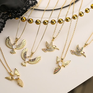 Eleganti collane con ciondolo a uccello in oro con zirconi su sfondo decorativo