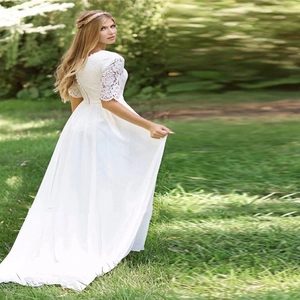 Elegant white lace wedding dress with short sleeves and a flowing floor-length chiffon skirt