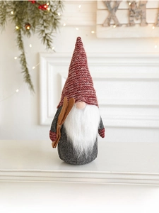 Detail of Christmas gnome with knit hat and wooden skis on festive holiday mantle