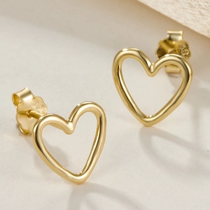 Minimalist gold S925 sterling silver heart-shaped stud earrings on beige textured surface