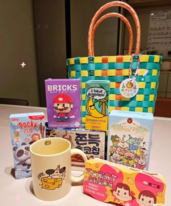 Detailed gift basket featuring a hand-woven tote bag, colorful ceramic mug, and snacks