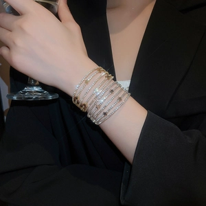 Sparkling multi-layer rhinestone bracelet with star charms worn in a formal party setting