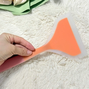 Close-up of flexible silicone spatula with pink handle and translucent white wide blade