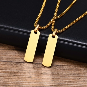Macro detail of polished gold rectangle pendants with durable box chains on leather