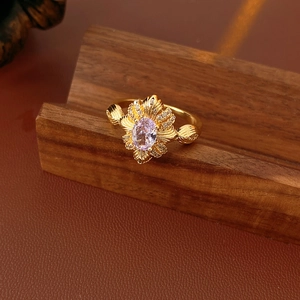 Nahaufnahme eines Vintage-Goldrings mit ovalem Lavendel-Edelstein und Zirkon-Blumen