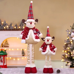 Detail of two Christmas reindeer plush figurines with red plaid hats in a festive setting